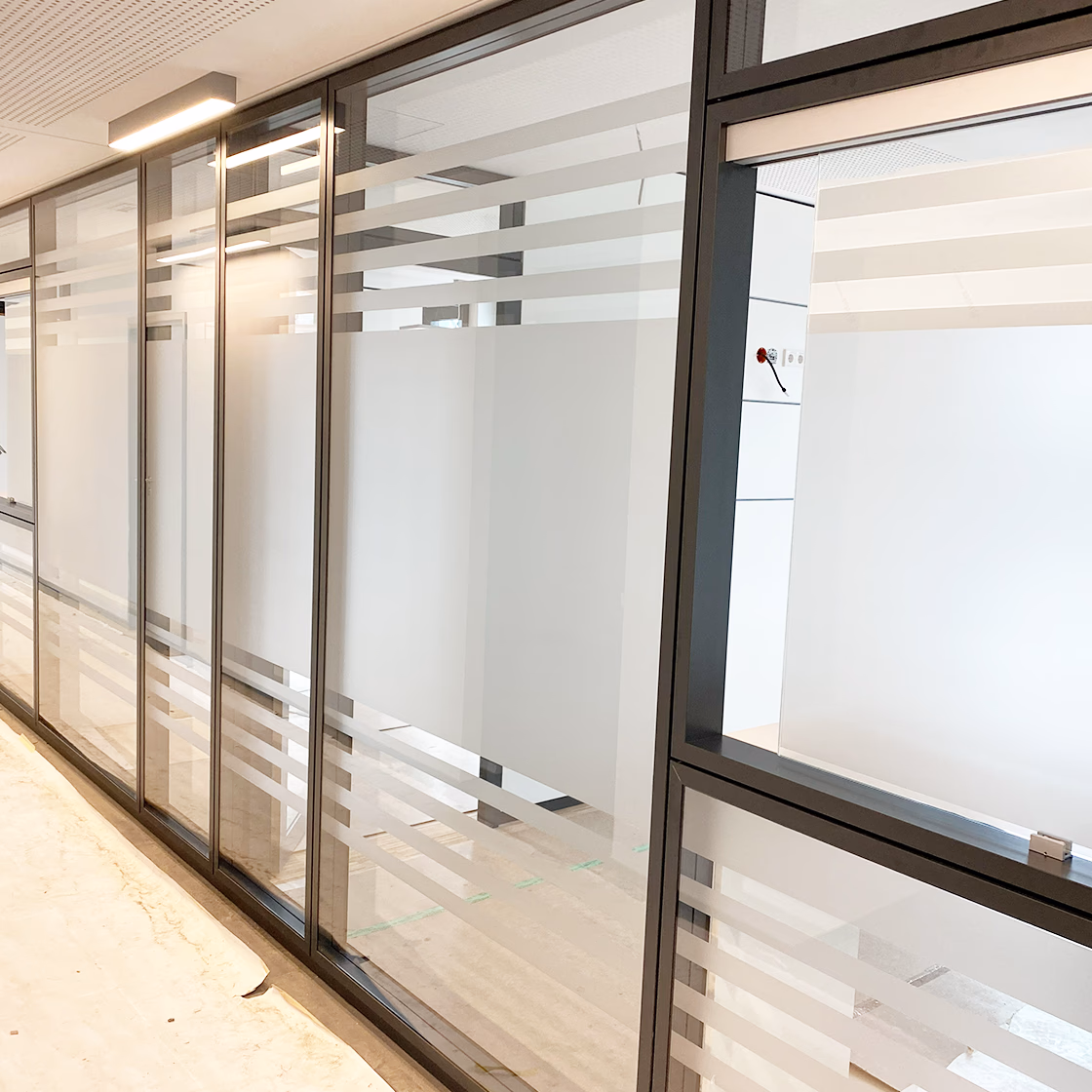 Montage von Milchglasfolie in München: Matte Folie als Sichtschutz für Fenster in einer Kanzlei.