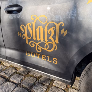 Professionelle Fahrzeugbeschriftung für ein Hotel: Firmenlogo und Schriftzug an der Autotür.